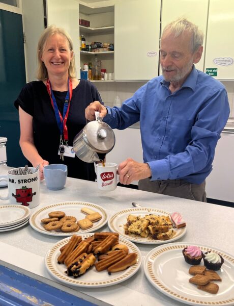 People pouring coffee and offering biscuits