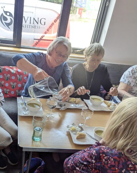 Three people sat round a table eating lunch
