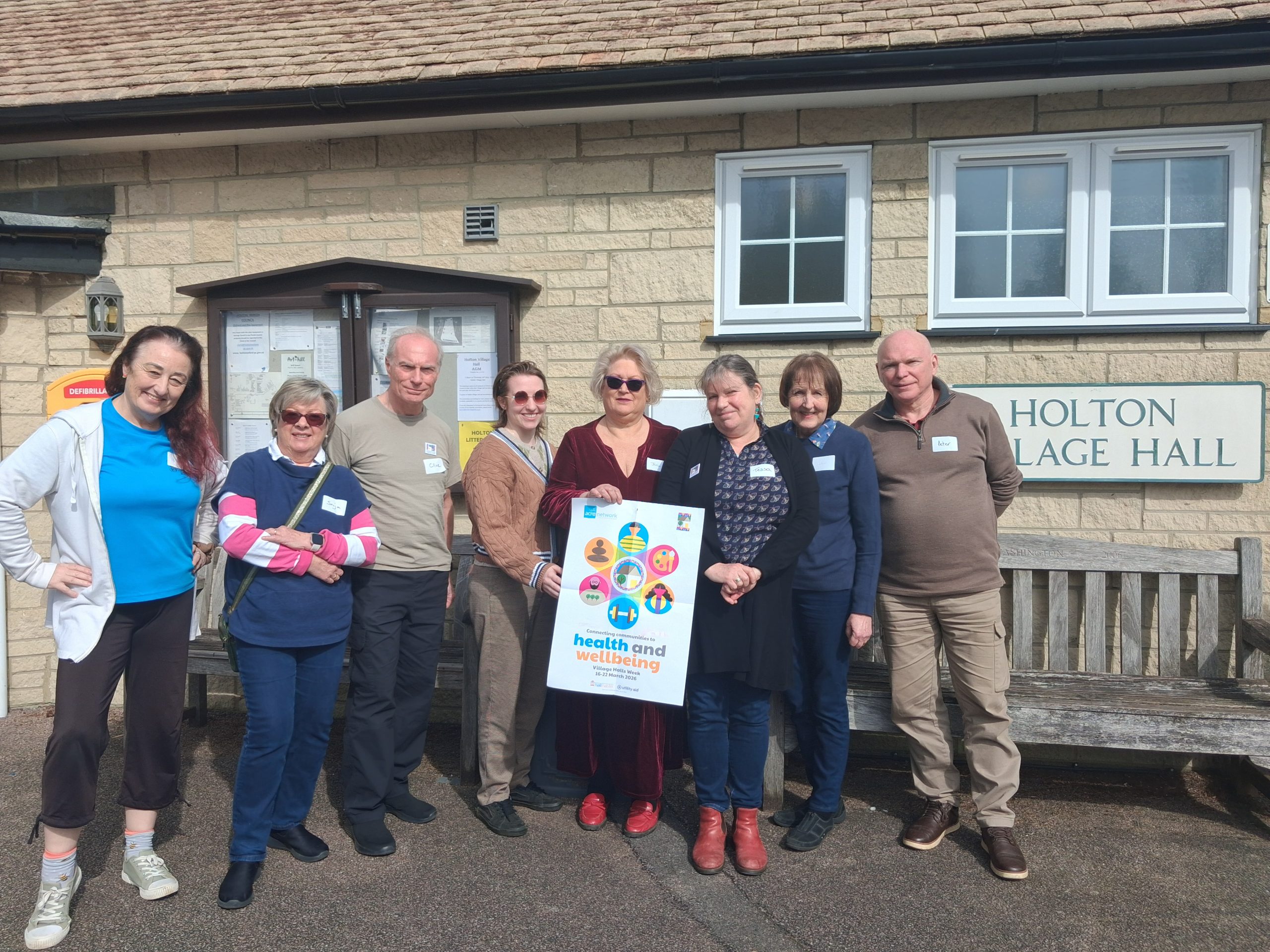 Group photo with village halls week poster